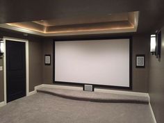 an empty room with a projector screen in the center and lights on either side