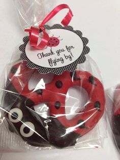 two red and black donuts wrapped in cellophane with a ladybug tag