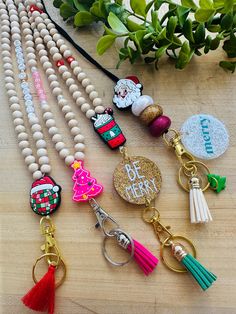 several keychains with different designs and tassels hanging from them on a table