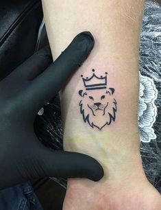 a small lion tattoo on the wrist