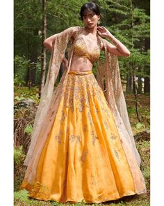 Shop this Suzy Organza Lehenga Set by Dolly J at KYNAH. This suzy organza lehenga set features a stunning yellow ombre organza blouse, paired with an organza cape jacket and leather belt for an elegant touch. Made from high-quality organza, this set is perfect for any special occasion, adding a pop of color and style to your wardrobe. Yellow Organza Lehenga, Lehenga Cape, Dolly J, Organza Cape, Chikankari Lehenga, Organza Bridal, Cape Set, Designer Bridal Lehenga Choli, Raw Silk Lehenga