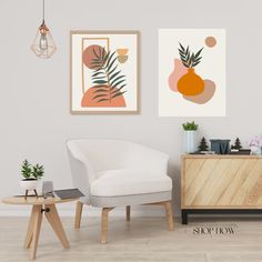 two paintings hang on the wall next to a white chair and sideboard with plants in it