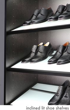 a row of black shoes sitting on top of white shelves