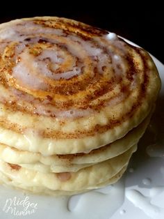 a stack of pancakes sitting on top of a white plate covered in cinnamon swirls