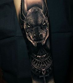 a man's arm with a black and grey tattoo design on it, featuring an image of a dog