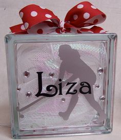 a glass block with a red bow on it and the word jozza written in black