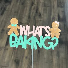 a cake topper that says, what's baking? with two gingerbread men on it