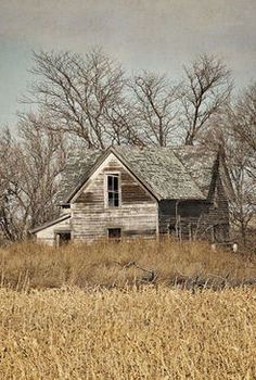 an old abandoned house sitting in the middle of a field