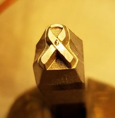 a close up of a metal object on a wooden table with gold flecks