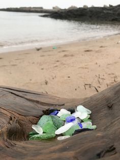 some sea glass sitting on top of a wooden log