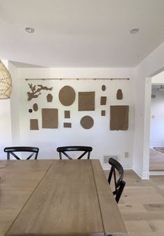 a wooden table sitting in front of a white wall with brown circles and shapes on it