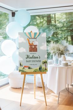 a baby shower sign sitting on top of a wooden easel