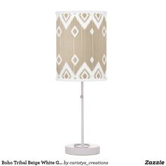 a lamp with a beige and white pattern on it's fabric shade is shown