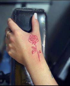 a woman's hand with a rose tattoo on it