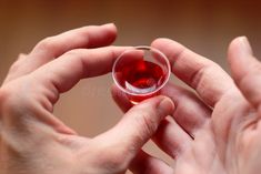 a person holding a wine glass with red liquid in it stock photos, images and clippings