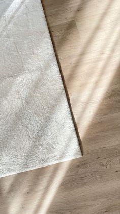 a white towel laying on top of a wooden floor