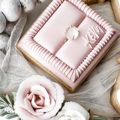 a pink square cake sitting on top of a table next to white and gray eggs