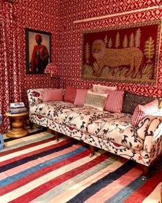 a living room with red and white striped rugs on the floor next to a couch