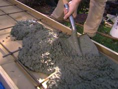 a man is shoveling cement into the ground