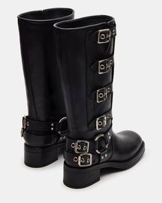 The ROCKY knee boot features the wide profile of an engineer boot with harness and buckle hardware adding an industrial edge and giving the design an adjustable fit. Block heel engineer boot Slip-on style Top gore with 4 adjustable buckle straps 2 inch heel height Size 6 measurements: 14.5 inch shaft circumference, 12.5 inch shaft height Size 8 measurements: 15 inch shaft circumference, 13 inch shaft height Size 10 measurements: 16 inch shaft circumference, 13.5 inch shaft height Leather upper m Platform Slip Ons, Black Buckle Boots, Summer Wardrobe Staples, Engineer Boots, An Engineer, Shoes Sandals Heels, Leather Wear, Knee Boot, Buckle Boots