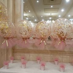 pink and gold balloons are on display in front of a mirror