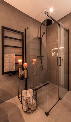 a bathroom with a walk in shower next to a white sink and two candles on the counter