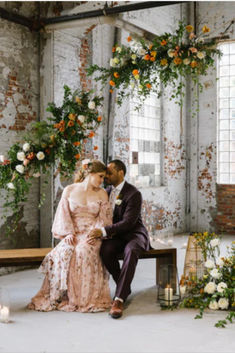 Bride and groom on bench in industrial event space with exposed brick and orange, white and pink floral installations at new Baltimore wedding venue The Butterfly Room. Outdoor Beer Garden, Industrial Chic Style, Industrial Garden, Industrial Wedding Venues, Rental Wedding Dresses, Floral Installation, Modern Mexican