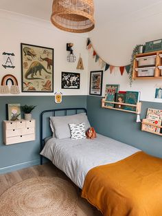 a bed room with a neatly made bed and lots of pictures on the wall above it