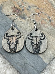 the earrings are decorated with an image of a bull's head and two horns