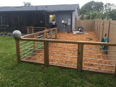 a fenced in yard with wood chips on the ground