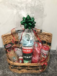 a basket filled with starbucks merchandise and wrapped in red ribbon, sitting on the floor