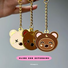 three bear key chains hanging from a hand