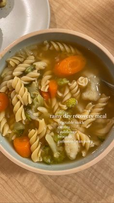 a bowl of pasta soup with carrots and broccoli