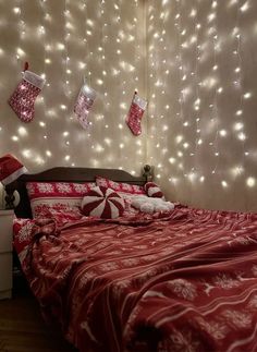 a bedroom decorated for christmas with lights and stocking on the wall above the bed