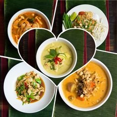 four bowls filled with different types of food on top of a green place mat in the shape of a heart