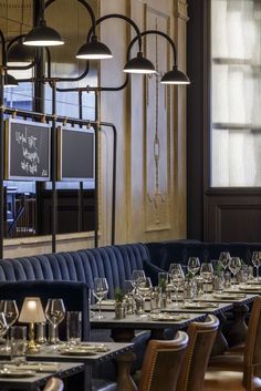 a long table with many glasses on it in a room filled with tables and chairs