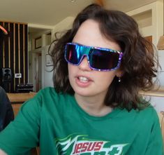 a man and woman sitting next to each other in front of a table wearing sunglasses