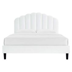 a white bed with an upholstered headboard