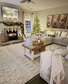 a living room filled with furniture and a christmas tree in the fireplace mantel on top of a white rug