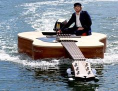 a man sitting on top of a wooden boat in the water next to a dolphin