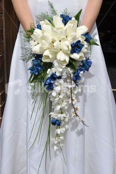 a bride holding a bouquet of white and blue flowers