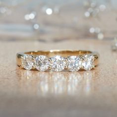 three stone diamond ring sitting on top of a table