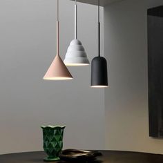 three lights hanging from the ceiling above a table