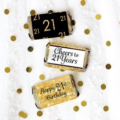 two candy bars with happy 21st birthday written on them sitting next to each other in front of gold polka dots