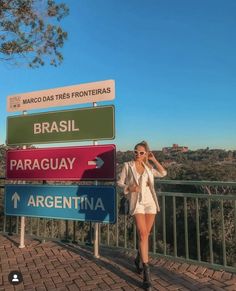 a woman standing next to a street sign