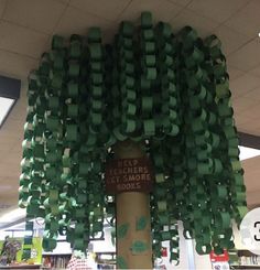 there is a tree made out of green ribbon on the store's book shelf