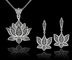 "This 925 sterling silver filigree art blossoming lotus flower pendant and dangle drop earrings set is a true work of art. The filigree silverwork is delicate and intricate, creating a beautiful open-air design that showcases the lotus flower in full bloom. The dangle drop style of the pendant and earrings adds a touch of movement to the overall design, making this set both stylish and eye-catching.       Whether you're dressing up for a special event or just want to add some beauty to your everyday look, this set is sure to make a statement. The sterling silver material also ensures that this set will last for years to come, making it a great investment piece for your jewelry collection. Earrings; The length of the earrings is 1.70\"  and the width is 0.90\". The total weight is 7.50 gr. Sterling Silver Dangle Jewelry With Intricate Design, Fine Jewelry With Filigree Dangle, Fine Jewelry Dangle Earrings With Filigree, Teardrop Jewelry With Intricate Design For Gifts, Silver Filigree Jewelry Sets As Gift, Elegant Filigree Jewelry Sets, Traditional Flower Shaped Jewelry, Silver Flower Pendant Jewelry With Matching Earrings, Fine Jewelry Filigree Drop Earrings