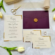 the wedding stationery is laid out on top of the table with flowers and scissors