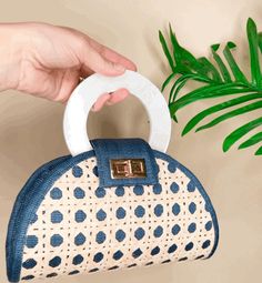 Introducing the Soli & Sun statement resort style bag, crafted with a unique blend of traditional and modern materials. Made from woven rattan Solihiya and navy blue t'nalak fabric, both woven by the skilled women of the T'boli tribe of Lake Sebu in the Philippines. This bag features a striking iridescent shell inlay handle, adding a touch of elegance and luxury to its overall design. Perfect for any beach or resort outing, this bag will elevate your style and make a statement wherever you go. D Blue Summer Bags With Bamboo Handle, Blue Bags With Bamboo Handle For Everyday Use, Blue Tote Bag With Bamboo Handle, Blue Tote Bags With Bamboo Handle, Blue Everyday Bags With Bamboo Handle, Blue Travel Bag With Bamboo Handle, Blue Top Handle Shoulder Bag For Vacation, Chic Blue Handwoven Straw Bag, Blue Vacation Bag With Bamboo Handle