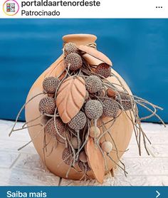 an image of a vase that is on the ground with dry grass in it's center